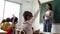 Asian school teacher with students raising hands. Young woman working in school with arm raised, school children putting