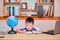 Asian schoolboy kid using laptop computer studying homework during his online lesson at home, Distance learning, homeschooling