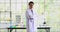 Asian scientist standing and moving his body in laboratory and talking to the camera.