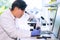 Asian scientist working in lab. Doctor making microbiology research. Laboratory tools: microscope, test tubes, equipment