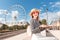 Asian self-employed girl or student learning a language over the Internet sitting with a laptop in the amusement Park with