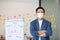 Asian senior business man in casual wearing mask Standing cross arms in modern office or co-working space