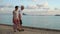 Asian senior couple elderly walking coastline beach morning anniversary retirement trip