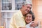 Asian senior couple embrace togerther and looking at camera and smiling in kitchen at home.Happy aging at home concept