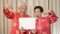 Asian Senior couple holding sign with copy space for Chinese new year surprise good deal