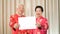 Asian Senior couple holding sign with copy space for Chinese new year surprise good deal