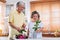 Asian Senior couple husband and wife flower arrangement to vase on table in kitchen at home in Valentine`s Day.lovely senior