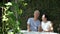 Asian senior couple laughing in green wall garden