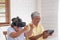 Asian senior couple play virtual realtiy glasses headset and tablet watching vr video and  have fun together in living room at hom