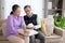 Asian senior couple sitting on sofa checking blood pressure with pressure gauge in living room at home.