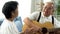 Asian senior couple sitting on the sofa and playing acoustic guitar together. Happy smiling elderly woman clapping hands
