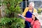 Asian senior couple smiling while watering green cultivated plants