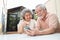 Asian senior couple talking in video call chat on mobile phone.
