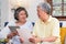 Asian senior couple use tablet searching about retirement financial document sitting on sofa at home,senior learn to use