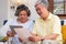 Asian senior couple use tablet searching about retirement financial document sitting on sofa at home,senior learn to use