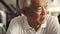 Asian senior elder man sitting looks happy in retro sepia tone close up