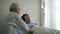 Asian senior elderly couple husband take care of ill wife at hospital admit love and worry