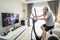 Asian Senior Elderly man workout cardio on cycling exercise bike machine at home for well being. Active Older male doing lockdown