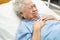 Asian senior or elderly old lady woman patient feel pain in the chest and heart on bed in nursing hospital ward; healthy strong