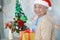 Asian senior or elderly old lady woman patient with Santa Claus helper hat holding gift box in Christmas and new year celebration