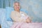 Asian senior or elderly old lady woman patient smile bright face while sitting on bed in nursing hospital ward