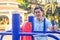 Asian senior gentleman making exercises on outdoor gym against green summer park as a background