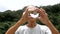 Asian senior  holding and look into a magic crystal glass ball on nature background.