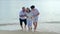 Asian senior love couple with son travel on the beach. Retirement age family relaxing and recreation on summer holiday