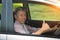 Asian senior male driving with thumbs up