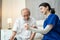 Asian Senior male patient consult with physician nurse at nursing home. Caregiver therapist pharmacist girl hold medicine pills