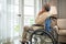 Asian senior man disabled sitting alone in wheelchair looking through window at hospital