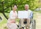 Asian senior man sitting on a wheelchair with caregiver and white board