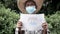 Asian senior wearing facial mask for protection from coronavirus epidemic when stay outdoors and holding a health campaign picture