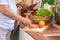 Asian senior wife slicing tomatoes on wooden cutting  board and using tablet computer to searching menu recipe.senior with technol