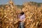 Asian senior woman with chart holder report examine product seed  farmer in golden view of dry leaves corn field background ready