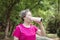 Asian Senior woman drinking water after exercising