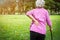 Asian senior woman hands touching back pain while walking in nature in summer,female patient having backache,muscle,hip pain in