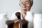 Asian senior woman holding drug bottle in front of medicine cabinet in her home,reading the label on a bottle for medical