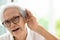 Asian senior woman listening by handâ€™s up to the ear,having difficulty in hearing,elderly woman hard to hear,wear glasses with