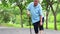Asian senior woman suffer from arthritis, osteoarthritis,elderly people walking,holding hand on the knee,feeling pain in the knee