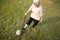 Asian senior woman with walking stick,playing with old football,healthy female elderly is kicking soccer ball,physical exercise,