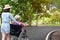 Asian senior woman in wheelchair with little child girl supporting disabled grandparent on walking green nature,grandmother and