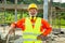 Asian senior worker engineer wearing helmet and safety clothes in the house construction site. Working elderly people concept