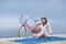 Asian sexy girl with hat sitting on the carpet in beach with bike behind it