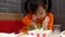 Asian sibling little girls enjoying with eating fried chicken, French fries and nectar in service shop with her family. KFC is a W