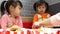 Asian sibling little girls enjoying with eating fried chicken, French fries and nectar in service shop with her family. KFC is a W