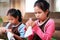 Asian siblings child girl enjoy making tie dye cloth together at home.