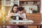 Asian single mother helping little daughter putting milk to glass with breakfast together at home kitchen in the morning