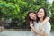 Asian sisters hugging and smiling in the park.