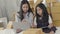 Asian sisters and sisters use a tablet computer to check the products to be delivered to customers.